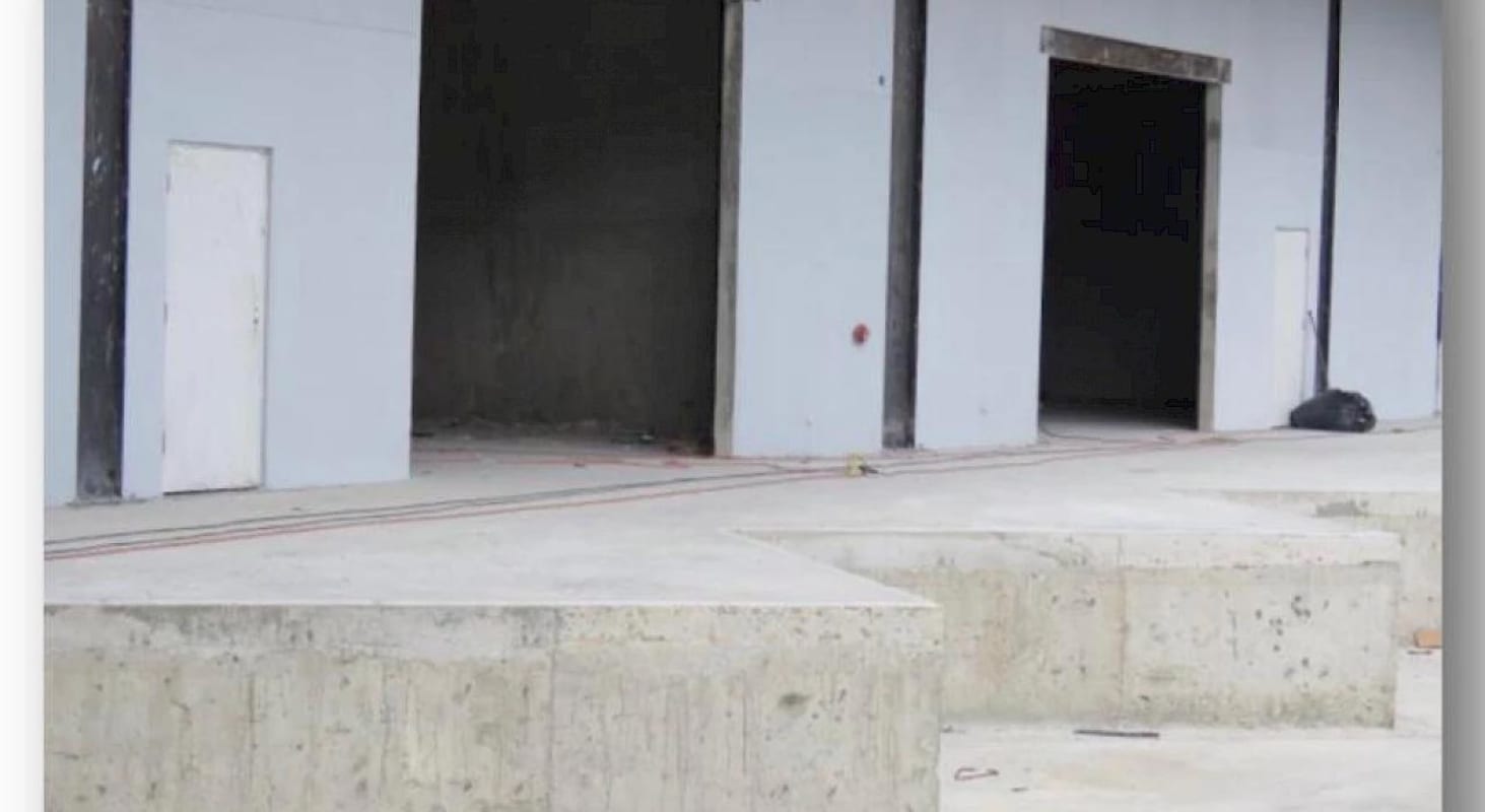 Interior empty warehouse with high ceilings, mezzanine level and large shutter door Parque Centenario Panama