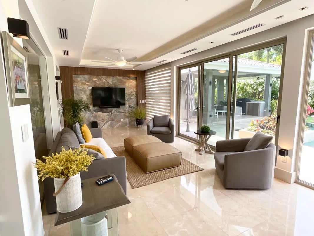 Spacious living room with marble floors and terrace access overlooking gardens in Fairway Estates Santa María