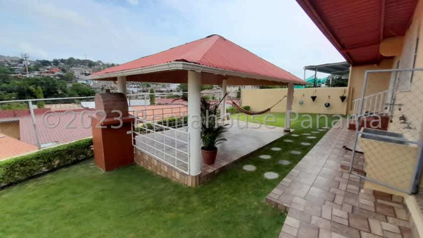 Covered bohio gazebo with hammock and barbecue in lush garden at El Bosque house Panama for sale