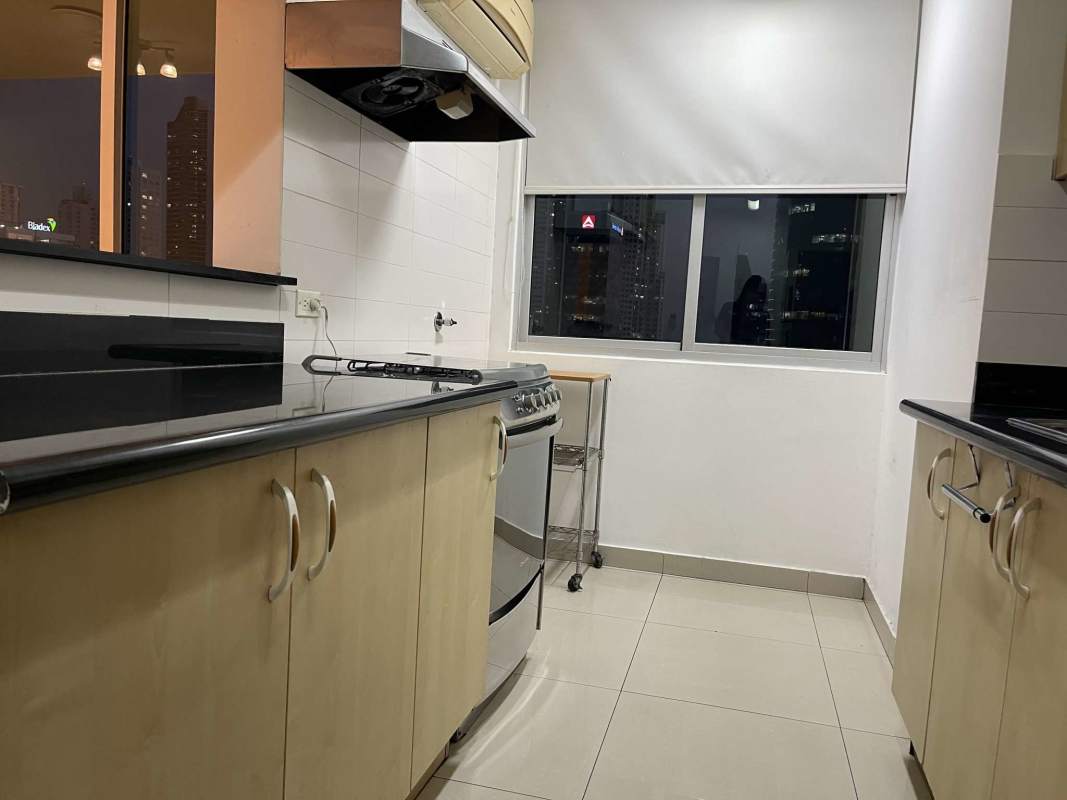 Modern kitchen with granite countertops and large window overlooking Panama City skyline at night PH Sevilla Towers Costa del Este