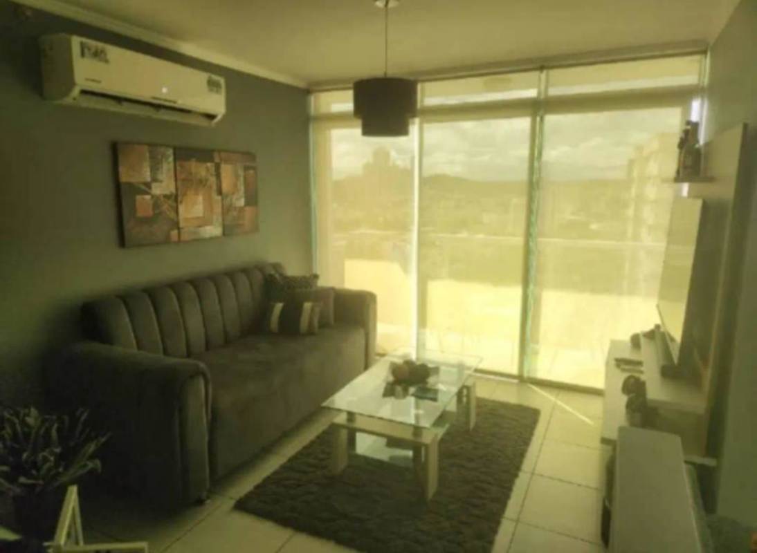 Modern living room with large windows, sectional sofa, city view PH Metropolitan Park Panama City