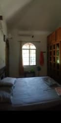 Rustic kitchen with wooden cabinetry, arched window, tile floor and skylight in house for sale in Penonomé