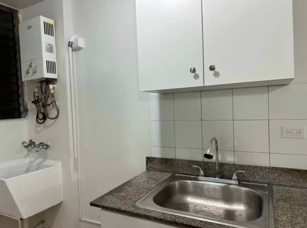 Laundry area with granite countertop, water heater, utility sink at PH Bella Vista Panama City