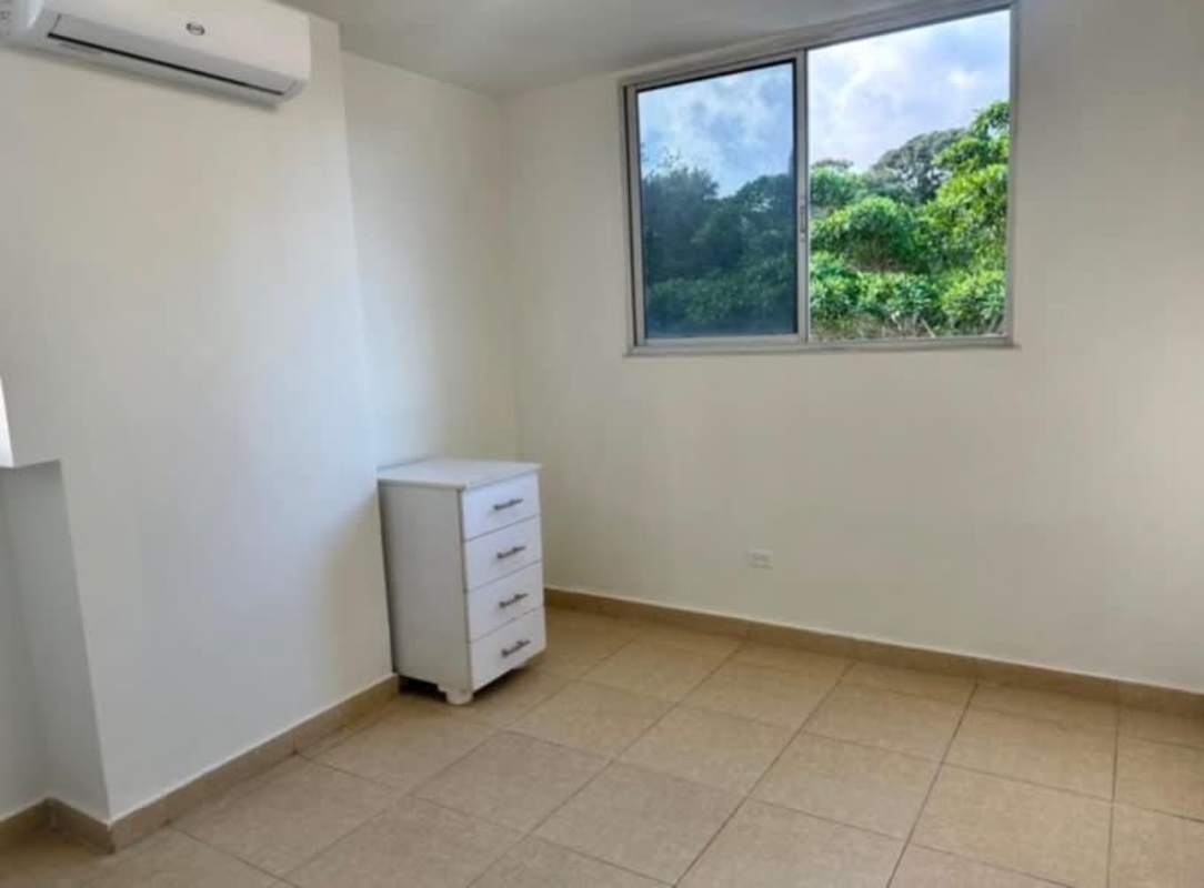 Minimalist bedroom with garden view, AC unit, and neutral walls at PH Bella Vista Panama