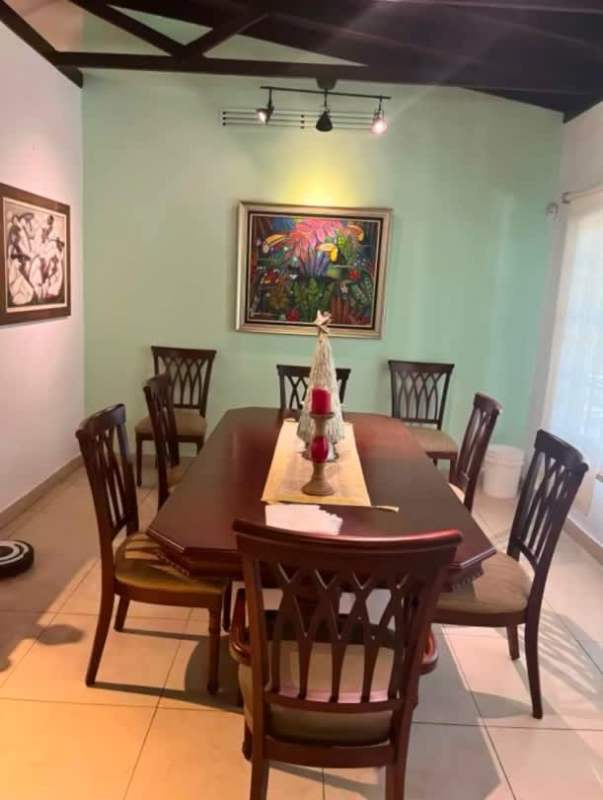 Master bedroom with wooden ceiling beams, large windows, AC and tropical garden views in Clayton Panama