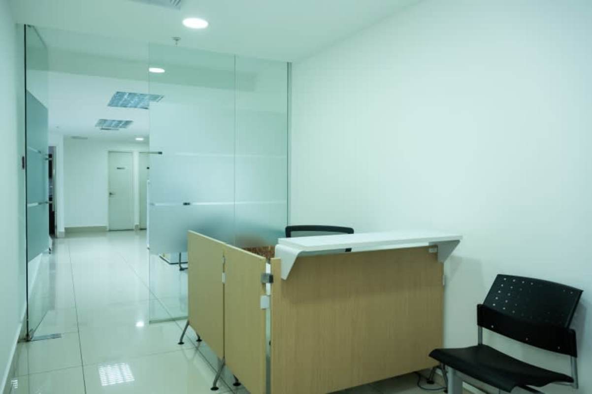 Open workspace with cubicles glass dividers and bright lighting in BICSA Tower