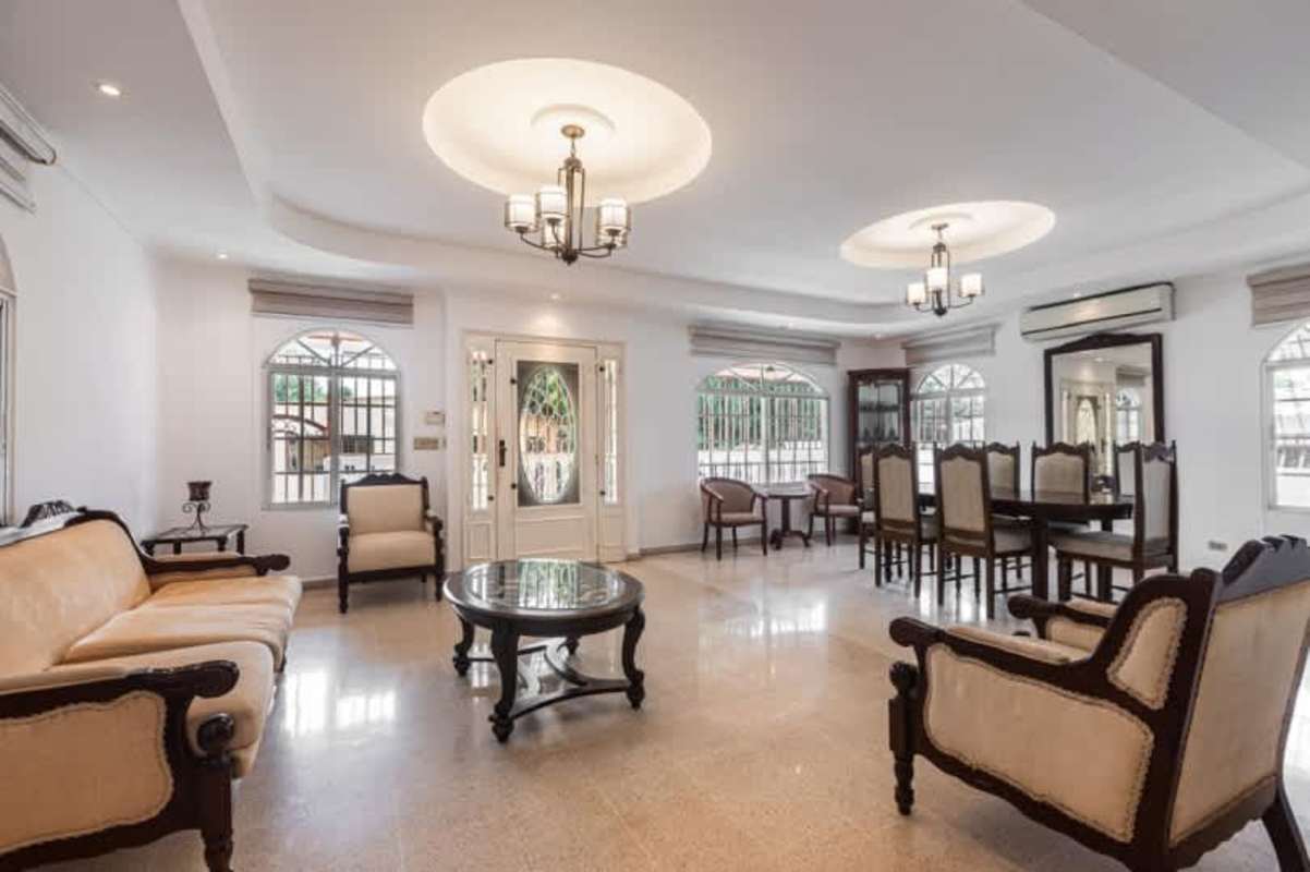 Open living and dining room with tile floors, arched windows, chandeliers in Rio Abajo Panama