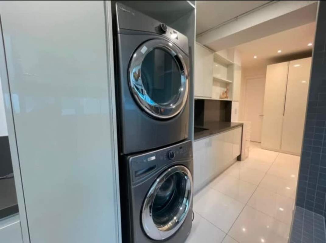 Laundry room with stacked washer-dryer, cabinets, modern finishes at PH Ocean Club Panama