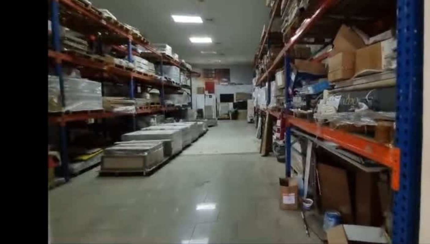 Warehouse storage space with shelving, boxes and lighting inside commercial building in Santa Elena