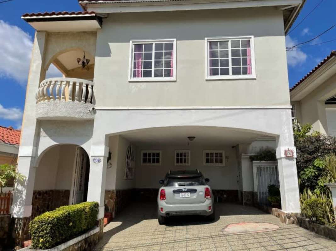 Two-story house with tiled roof, balcony, covered parking at Residencial El Doral
