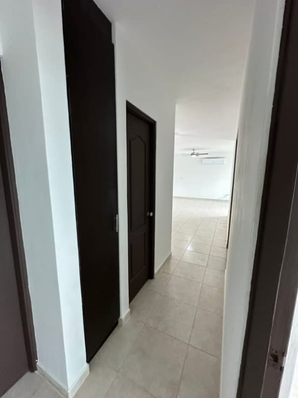 Hallway with ceramic tile, white walls and dark wood doors PH Park City Obarrio Panama