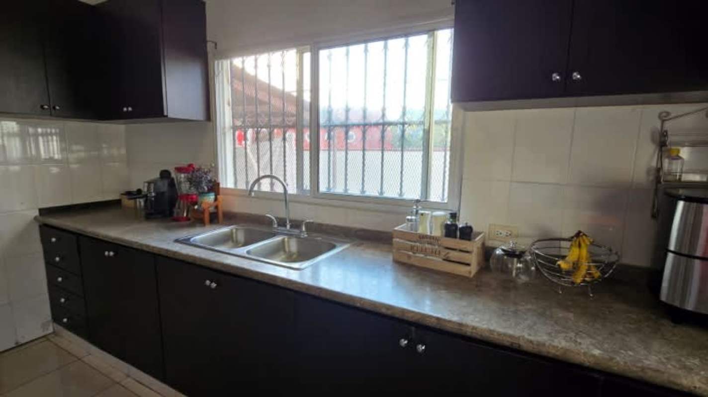 Full bathroom with tiled walls, vanity sink, toilet, and mirror cabinet in Panama