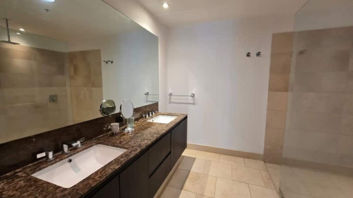 Elegant bathroom with double sinks and glass shower Ocean Reef Punta Pacífica Panama