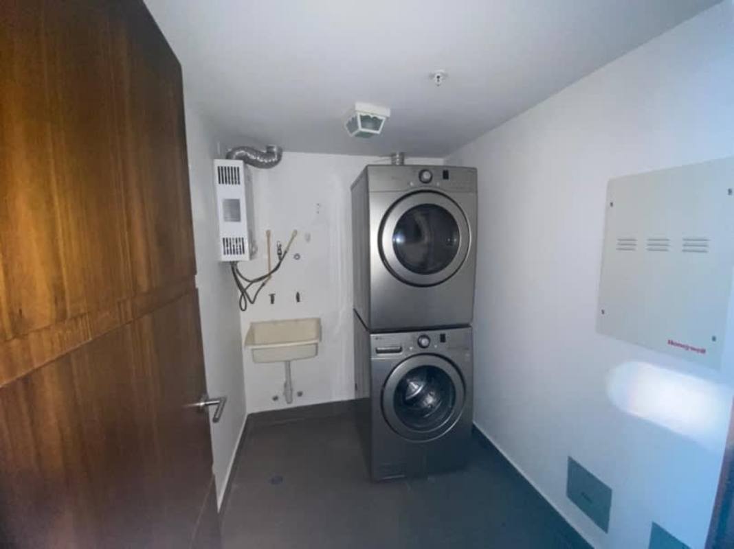 Laundry room with stacked appliance space utility sink in PH Coco del Mar Panama City