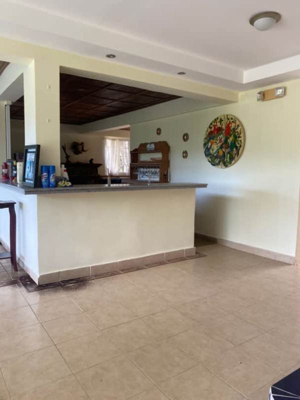 Modern rustic kitchen with granite countertops, mosaic backsplash, skylight, gas stove in Cerro Azul mountain house