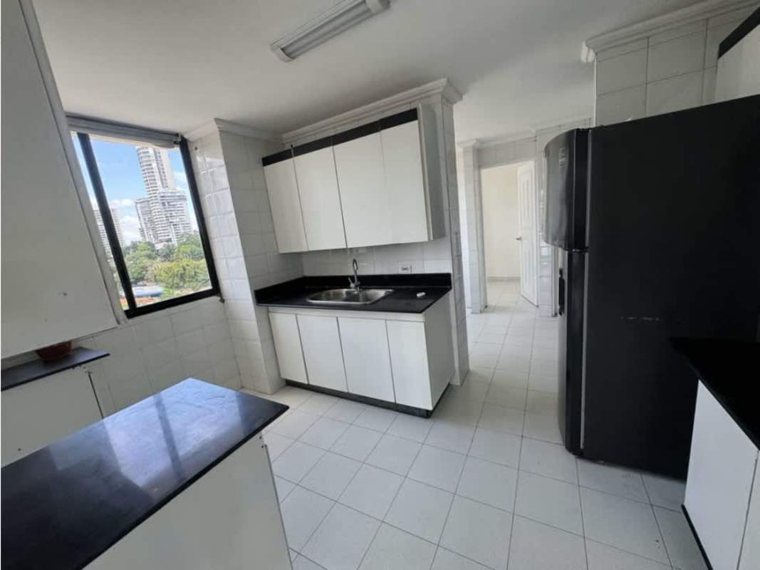 Large kitchen with granite countertops, white cabinets, big window with city skyline at PH Vista Tower Bella Vista Panama City