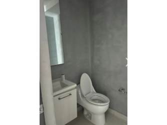 Living room with large windows, tile floor, dark accent wall in PH Miró condo El Cangrejo Panama City