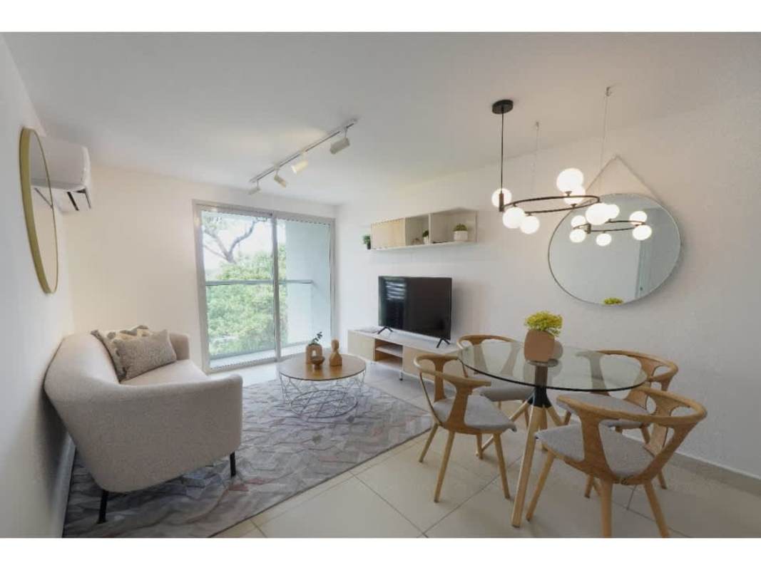 Bright open concept living and dining room with balcony access at Panama Viejo Residences Panama