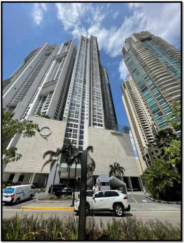 Tall modern high-rise PH Q Tower with glass windows and palm trees Punta Pacifica