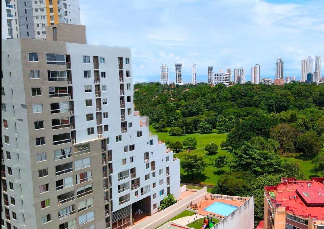 Outdoor swimming pool with park backdrop at Delavista apartments Panama