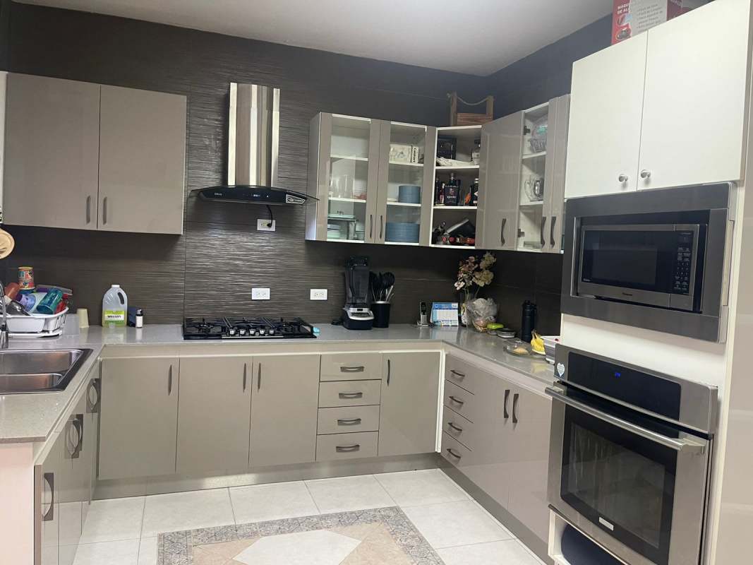 Front garden with flowerbed, iron gate, arched windows, tranquil street view in Panama City Altos del Chase