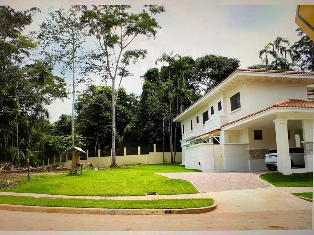 White Mediterranean two-story house tiled roof lush front yard Senderos Camino de Cruces Panama