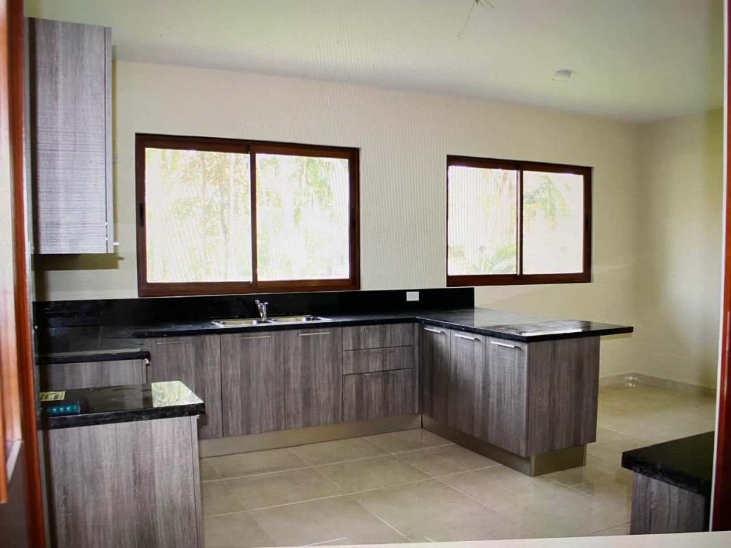 Bright hallway with large windows, metal railings and garden views in Senderos Camino de Cruces residence Panama