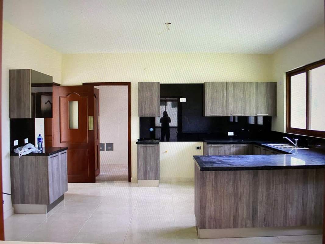 L-shaped granite countertop and modern cabinetry in luxury home kitchen Senderos Camino de Cruces