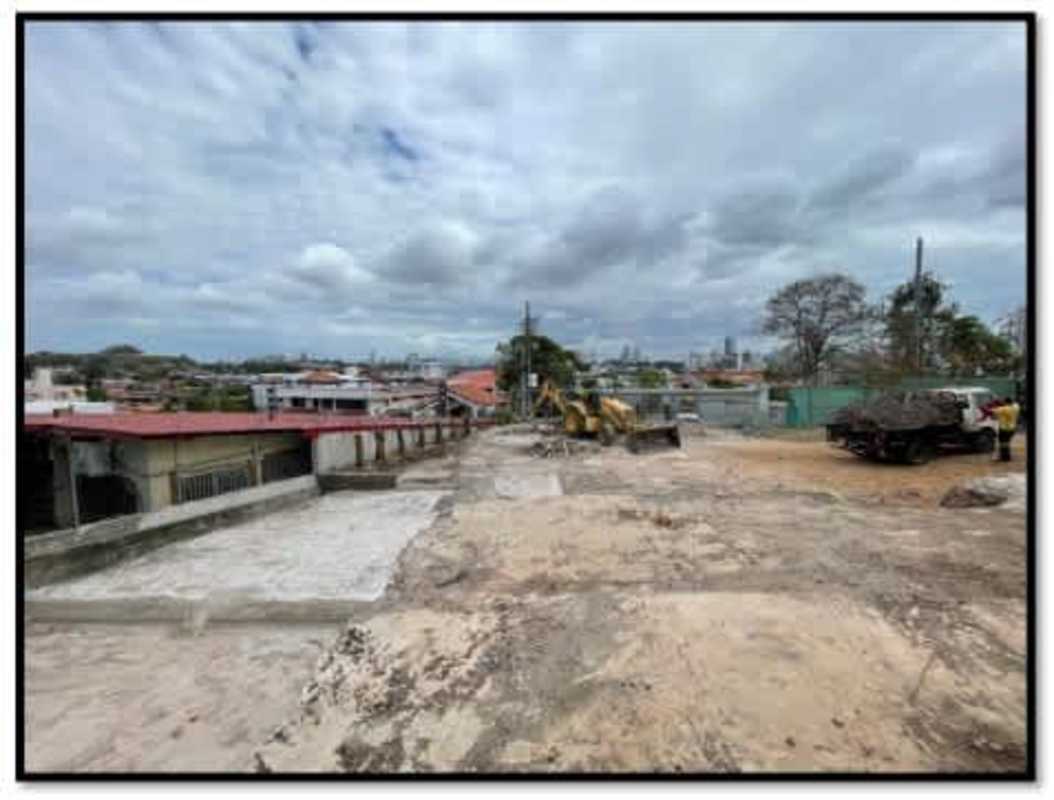 Vacant development lot with trucks and workers at Urbanización Los Angeles Pedregal Panama