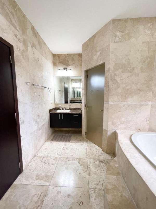 Glass enclosed patio featuring white dining set and lush garden views PH Sunset Coast Costa Sur Panama