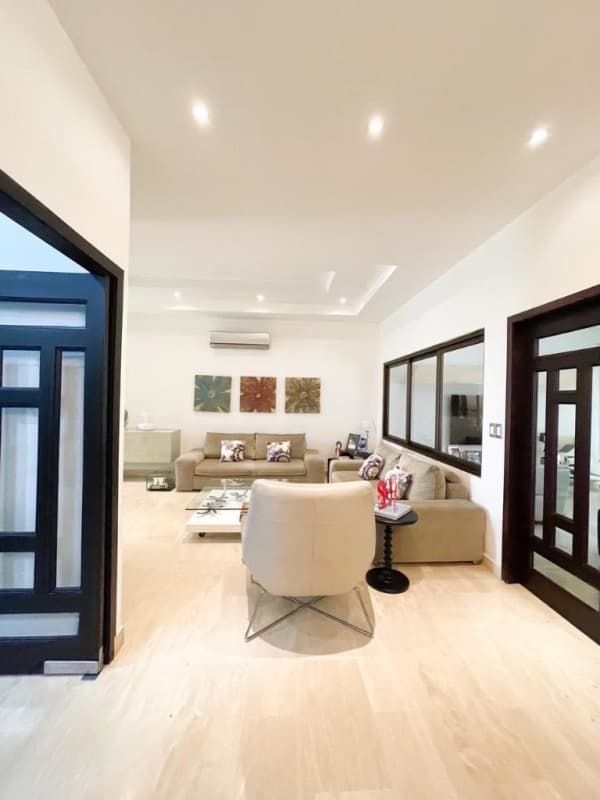 Glass enclosed terrace with dining area, orange accents, vaulted roof at PH Sunset Coast Panama