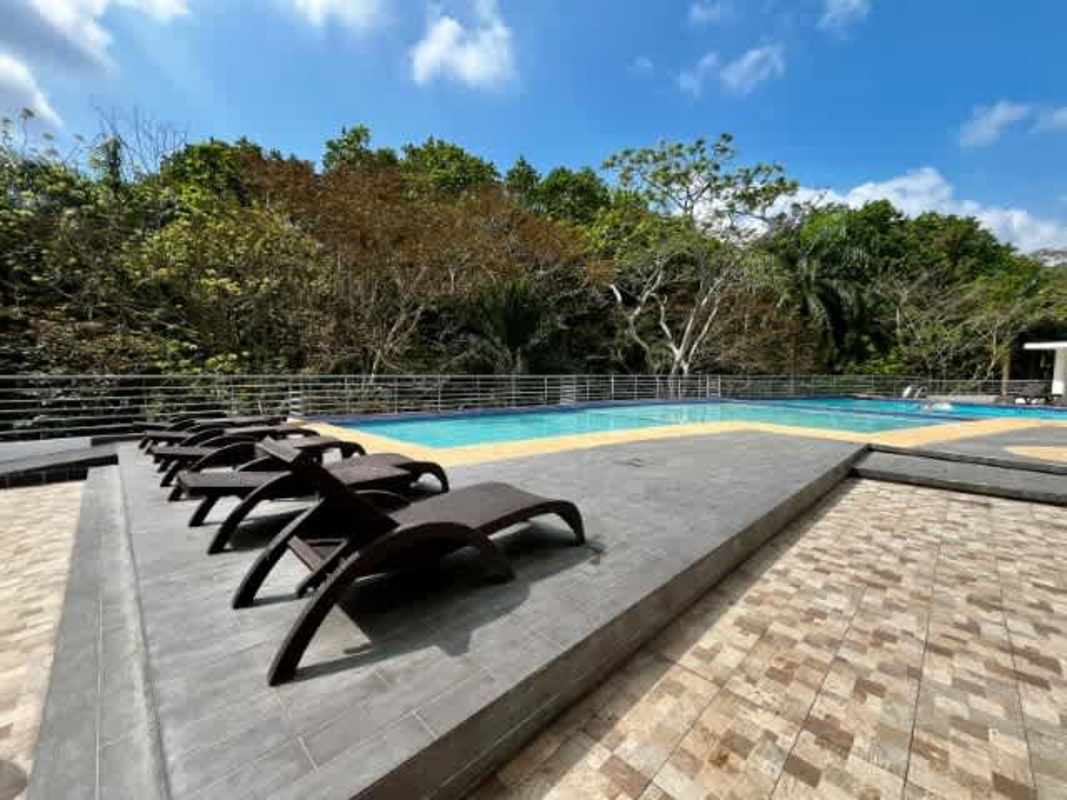 Bright bedroom with large window, double bed, closet, AC, natural light overlooking gardens in Clayton Panama