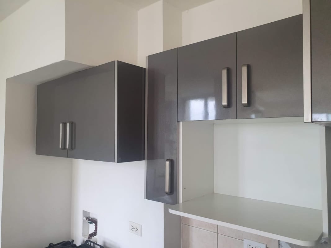 Upper cabinets with chrome handles in kitchen of PH Green Park Panama