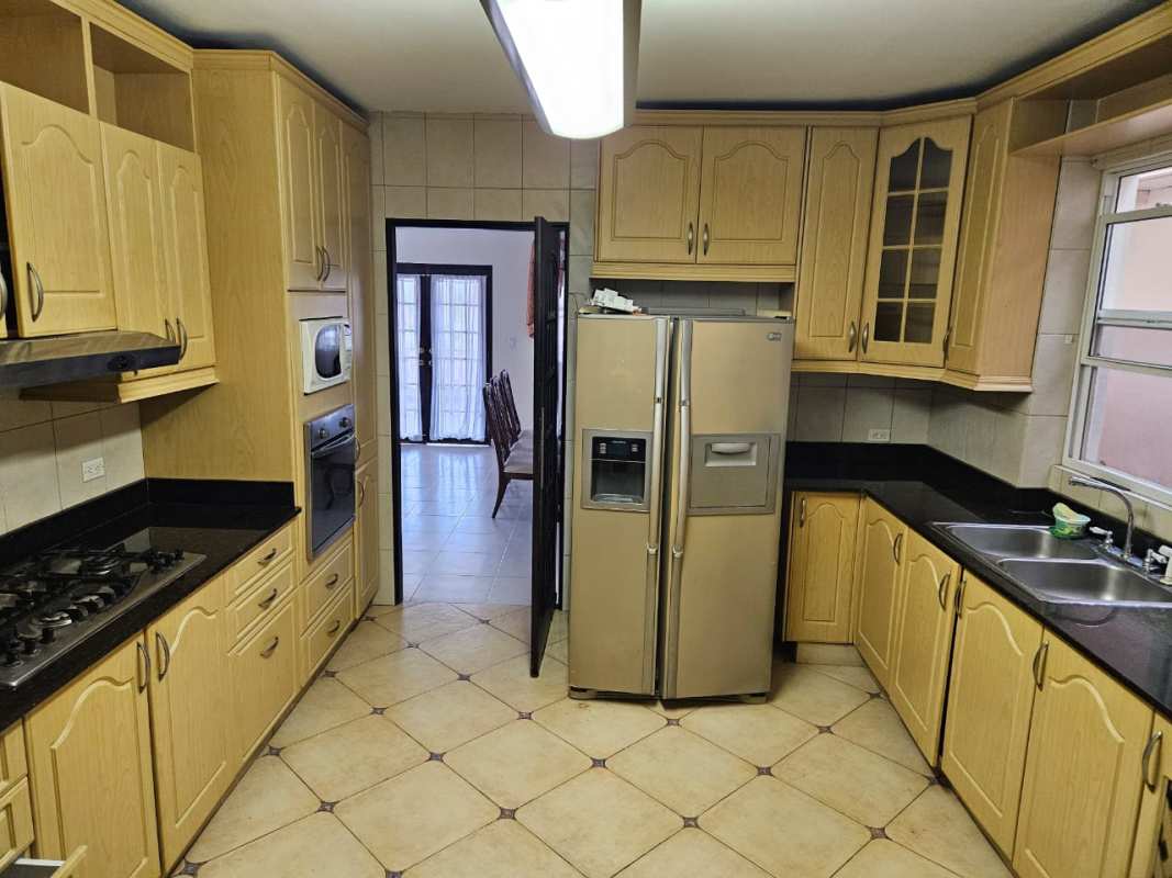 Side view Mediterranean house with walkway and garden plants El Doral Panama City