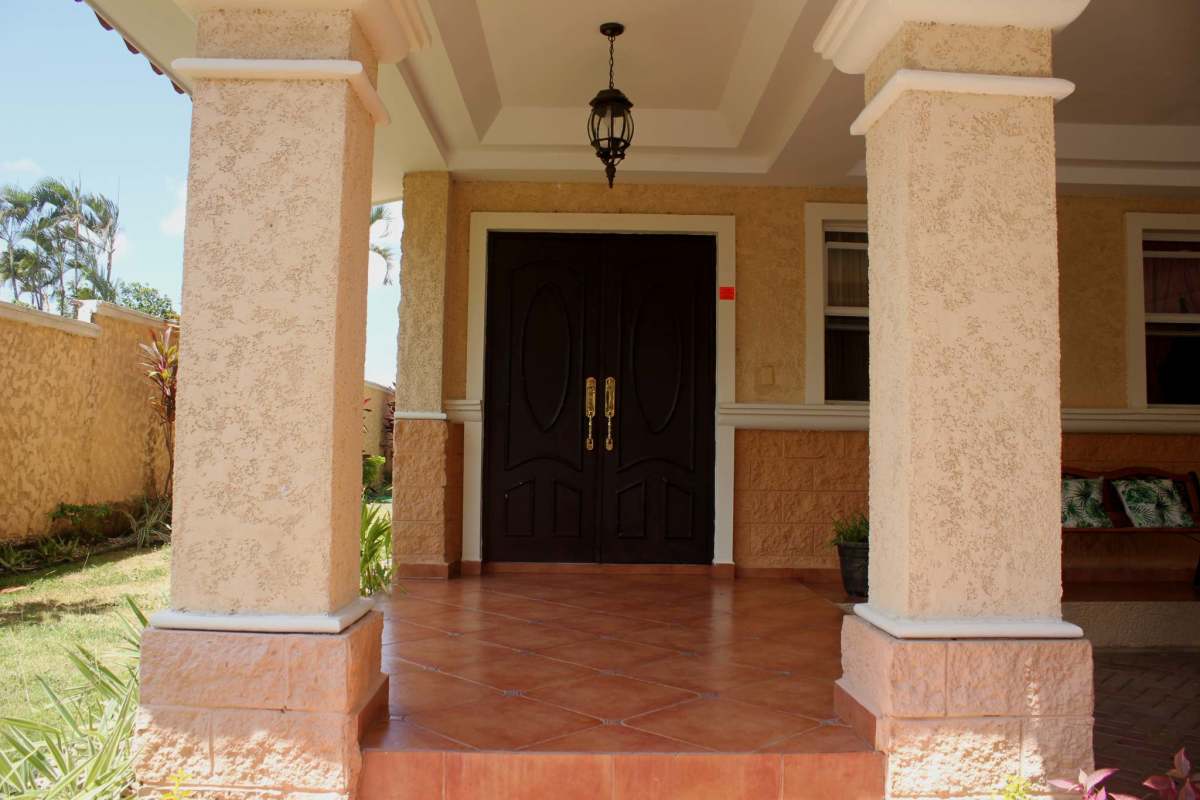 Mediterranean covered porch with columns, garden landscaping in El Doral house Panama