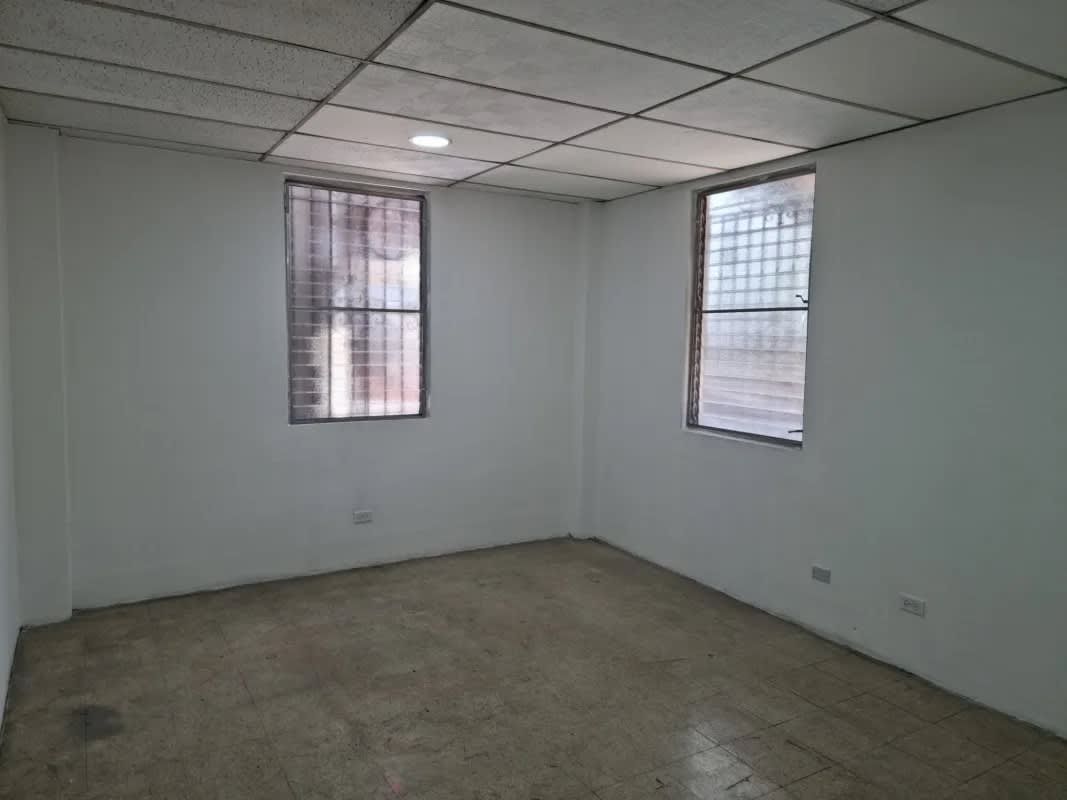 Large office room with tile flooring, barred windows, drop ceiling in Calidonia Panama