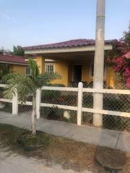 Front porch of yellow beach house with plants and fence Playa Santa Clara Panama