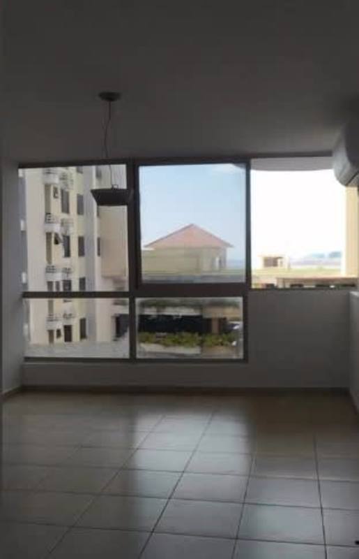 Living room with large windows, partial ocean and city views in PH San Francisco Tower Panama