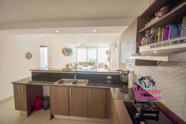 Bright open-plan living dining with large windows facing ocean at PH Waterways Playa Blanca Panama