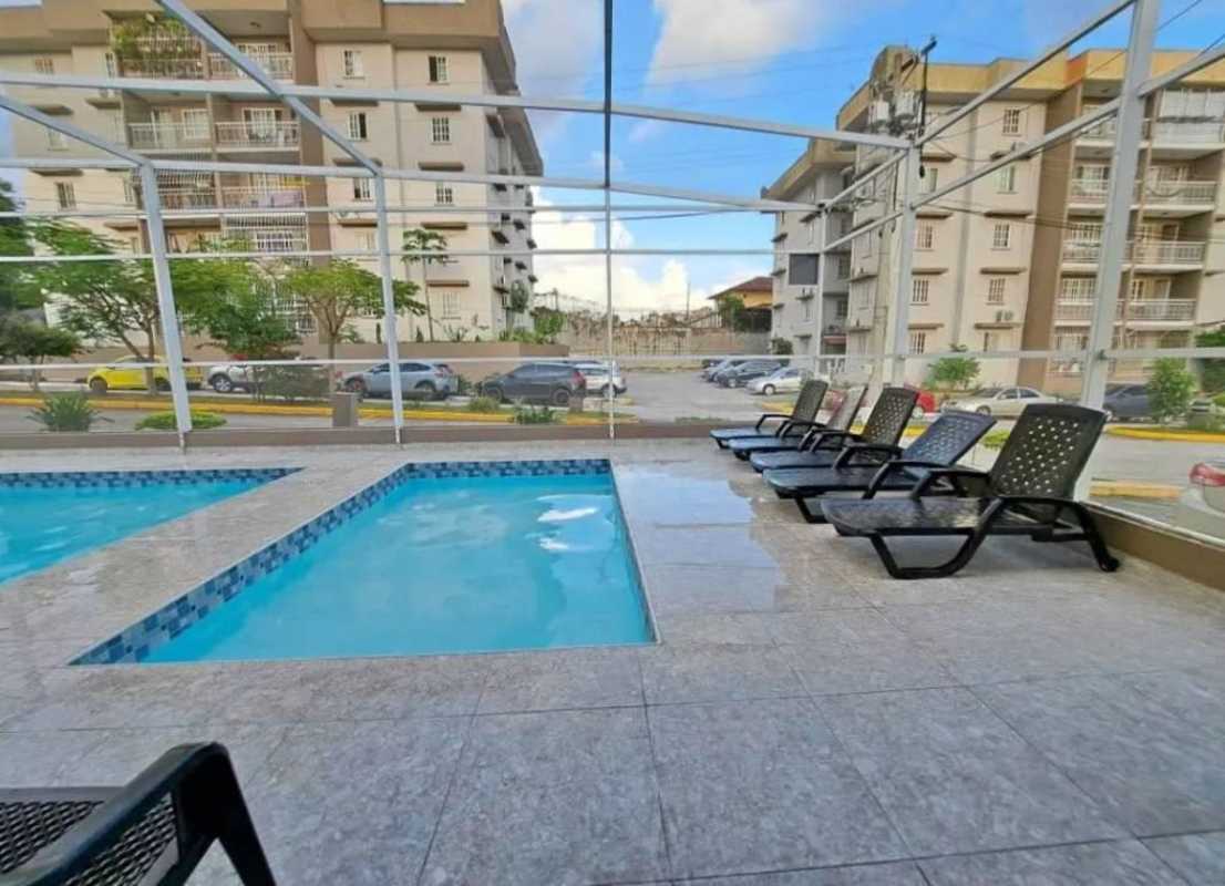 Outdoor swimming pool and lounge chairs in Villa Lucre Apartment Complex Panama