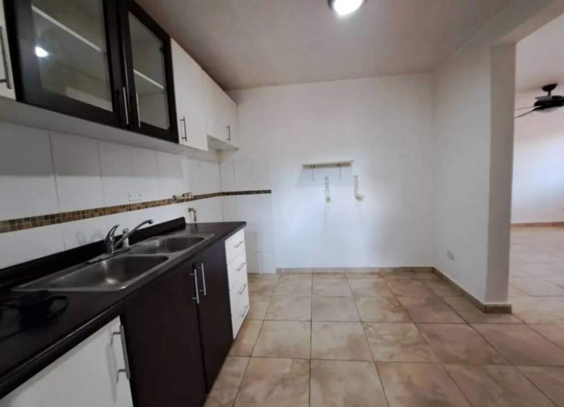 Modern open kitchen with black countertops, double sink, cabinets in Villa Lucre Apartment Panama