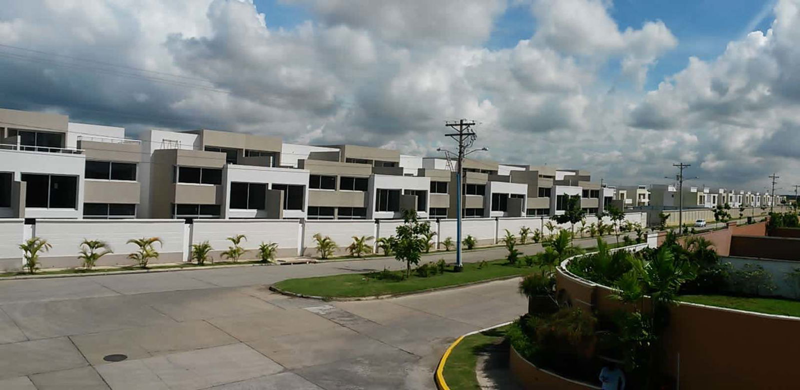 Gated suburban community with new contemporary townhouses, landscaped sidewalks, street view Costa Sur Panama City