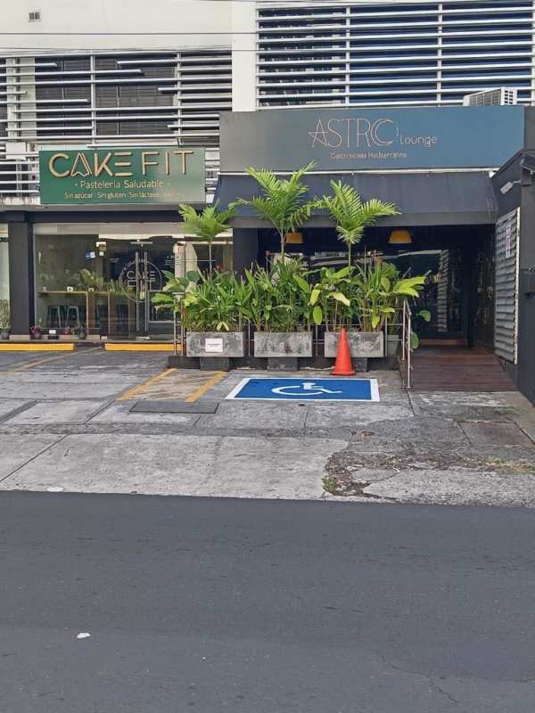 Two adjacent retail storefronts featuring large glass windows, modern signage and accessible parking in Panama City