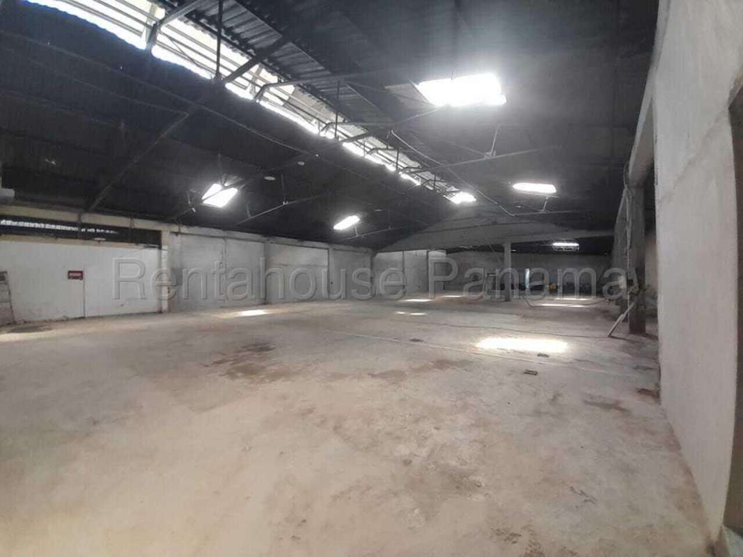 Wide open empty warehouse with skylights, exposed steel beams, and high ceilings Panama City
