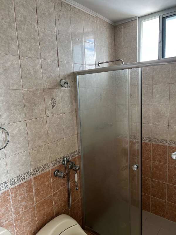 Bathroom with glass shower, pedestal sink, wall tiles in El Cangrejo Panama apartment
