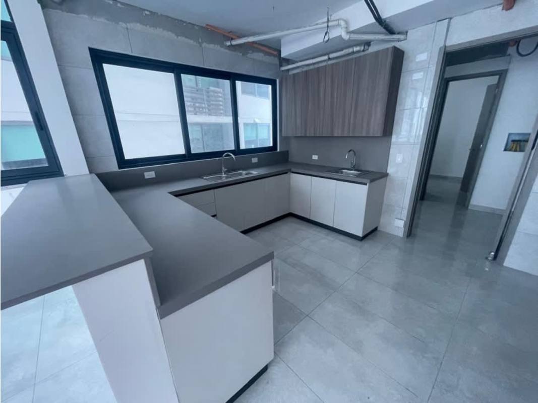 Modern kitchen area with L-shaped counter and large window PH Ocean Front Punta Paitilla