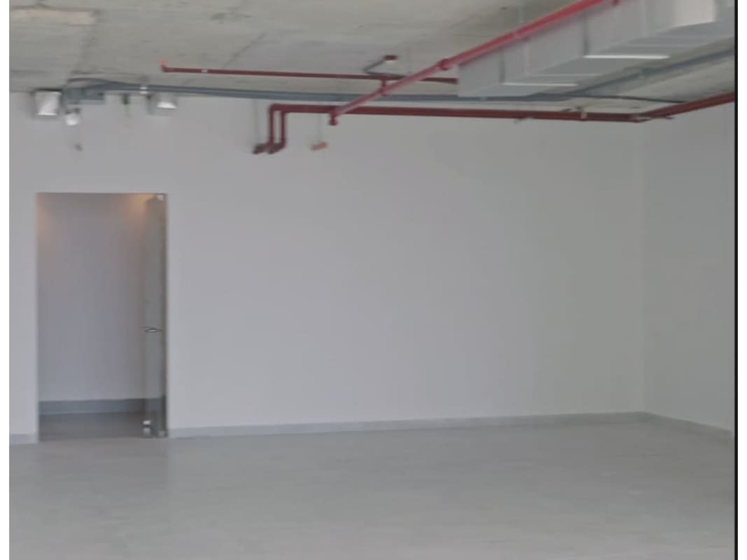 Unfinished open office floor with exposed piping, high ceiling, glass doors PH Sortis Business Center Panama