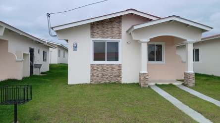 Exterior of new one-story house with porch and yard Bosque Dorado Playa Leona Panama