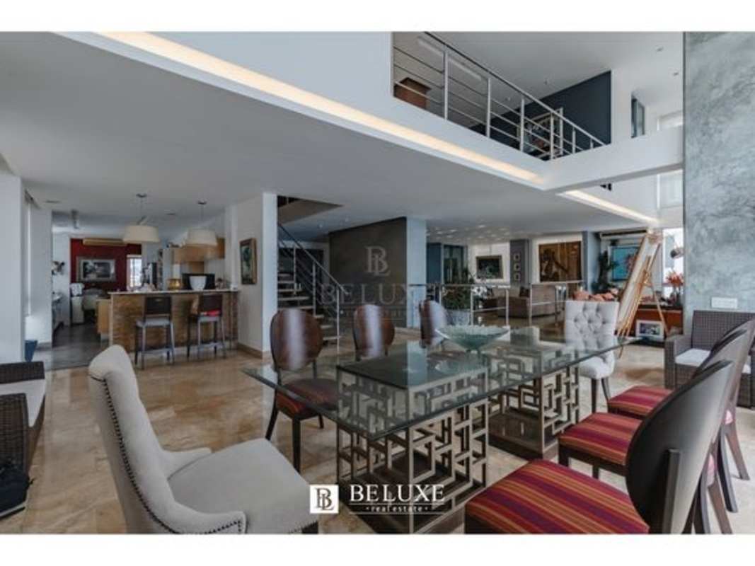 Large gourmet kitchen with granite counters, wooden cabinetry, breakfast bar at PH Premier Loft penthouse Panama City