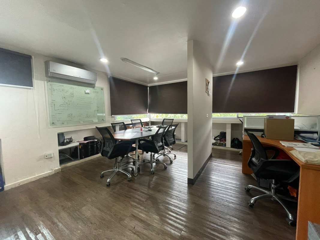 Conference meeting room area with wood floors, blackout blinds, glass whiteboard in Villa de las Fuentes Panama